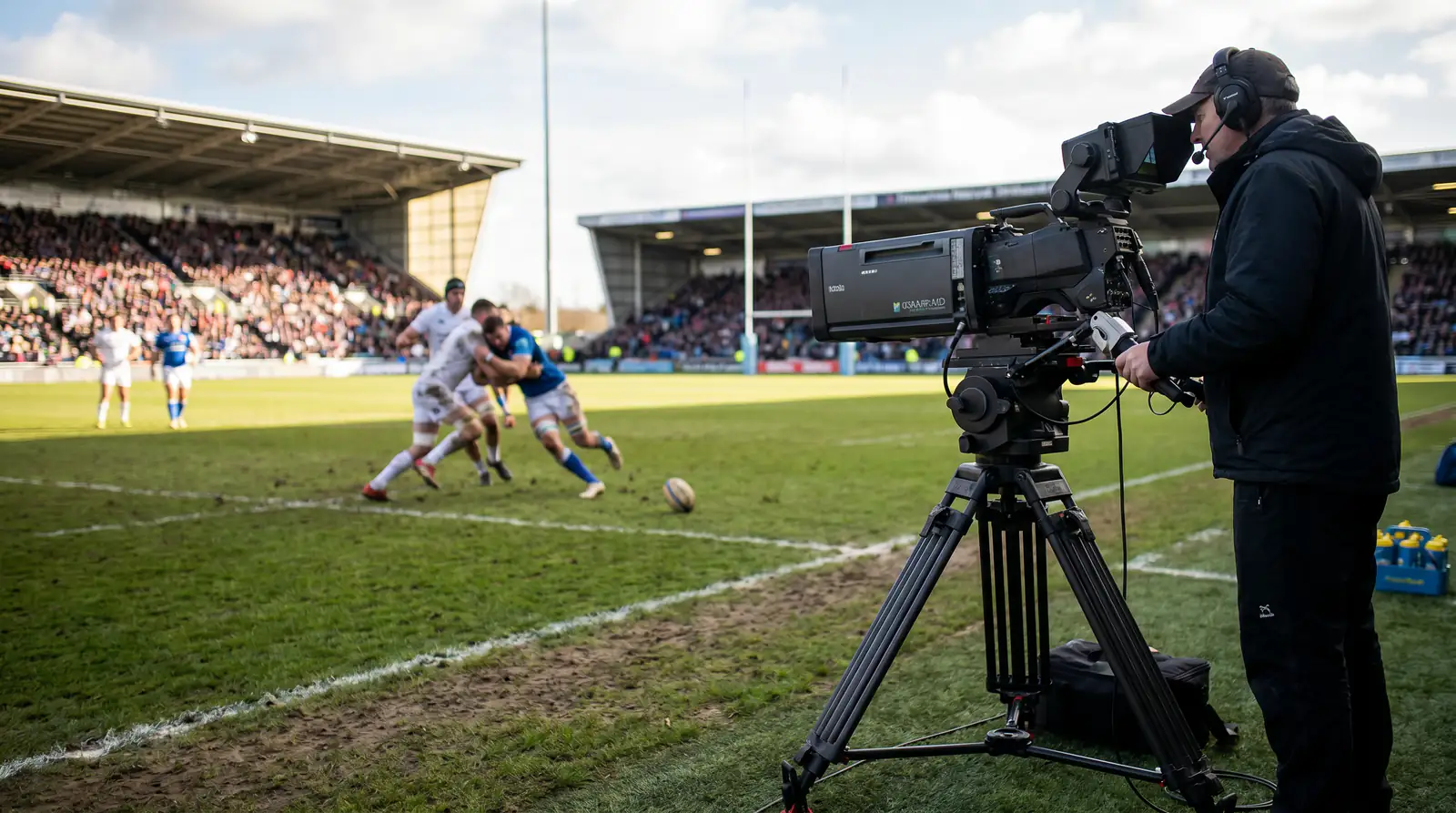 Broadcast television camera on the touchline of a packed rugby union international filming the match
