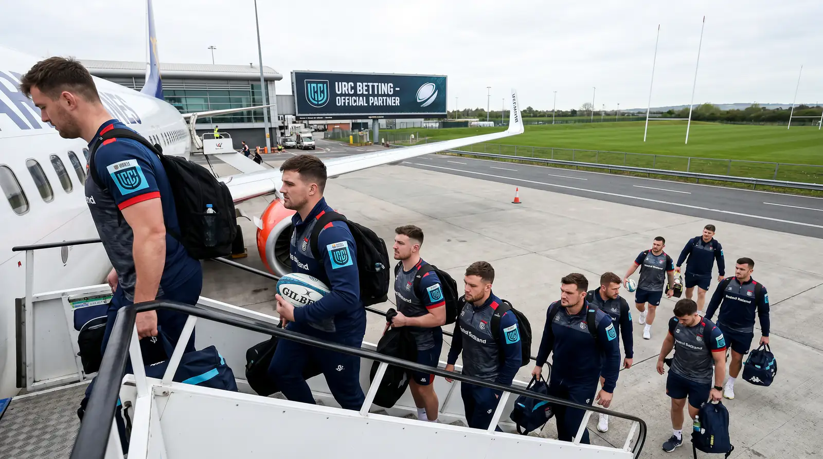 Rugby team boarding plane at airport for long-haul URC fixture